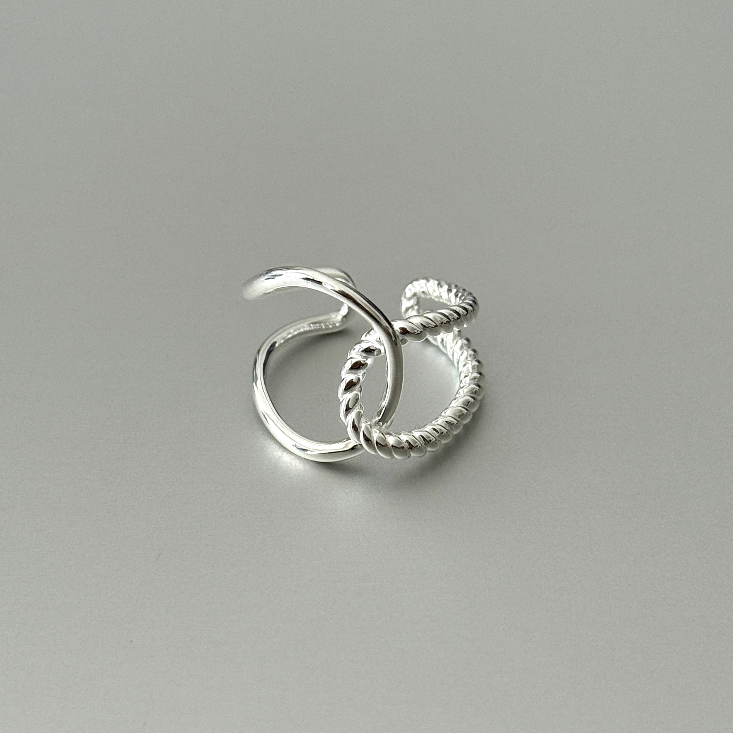 The Amara double wrap sterling silver ring on a finger, showcasing its unique half polished, half twisted rope design.
