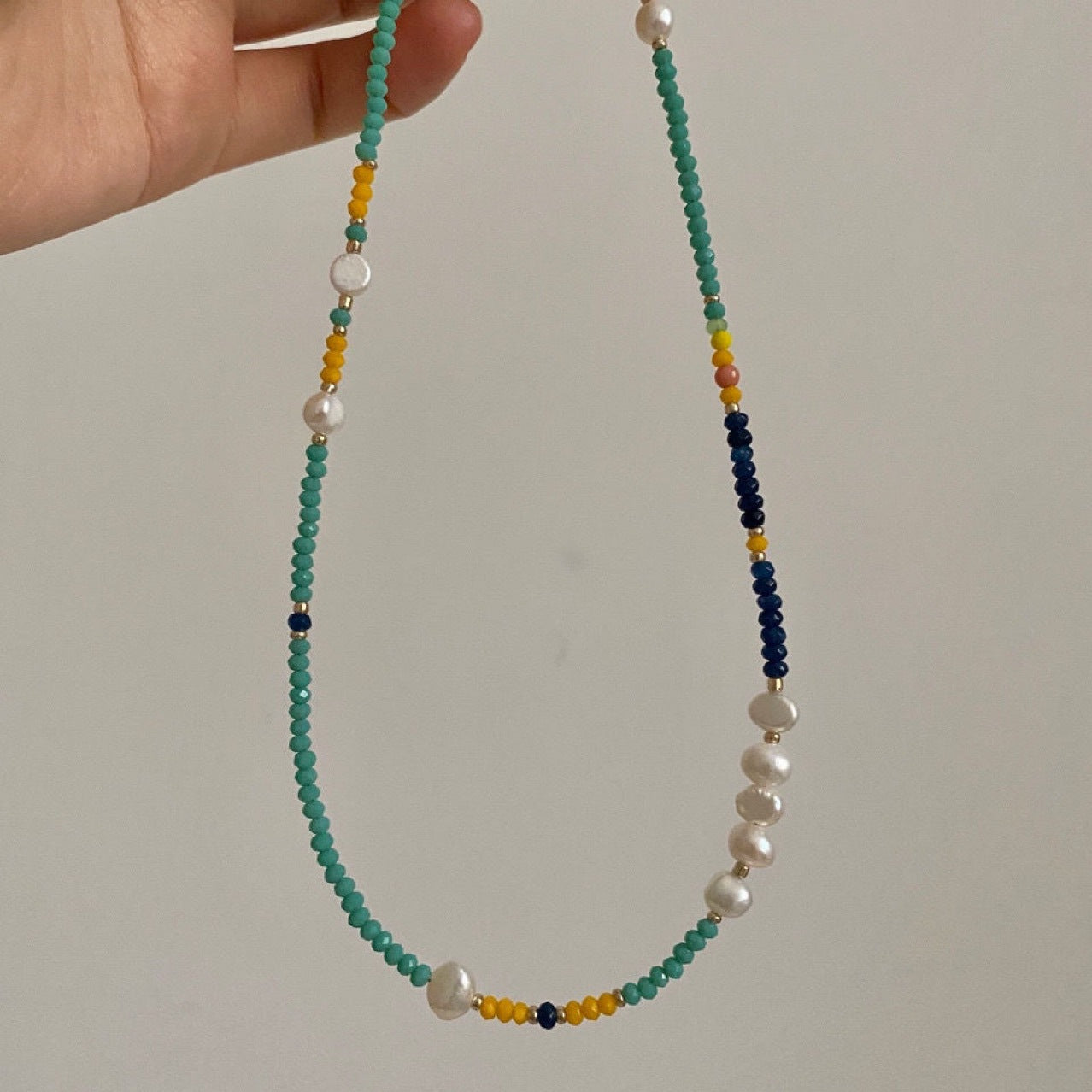 Close-up of Nova necklace's turquoise beads mixed with yellow, blue, and pink accent beads for summer color pop
