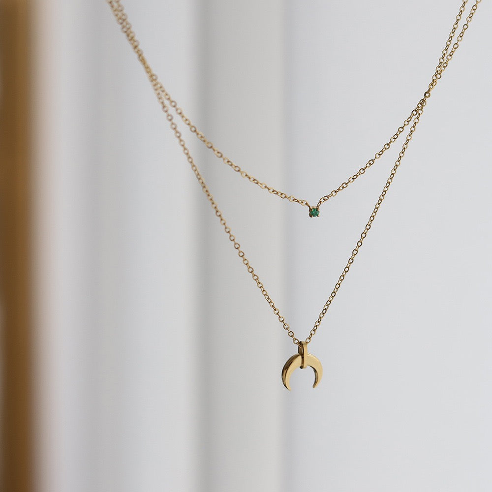 Detailed view of Silas necklace's green zircon stone on inner layer, capturing its emerald green sparkle