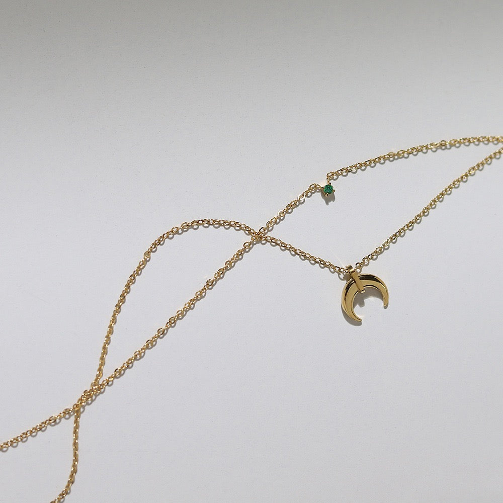 Close-up of Silas necklace's layered design, showing delicate gold chains and celestial elements