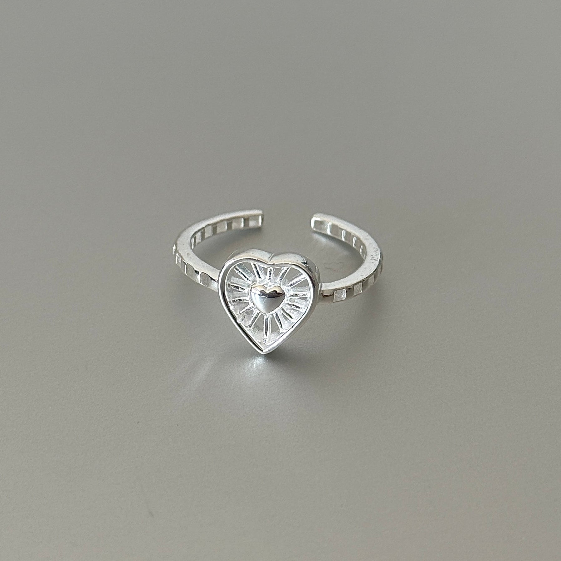 Detail shot showing the segmented band texture that complements the intricate sunburst design on the Thalia ring.