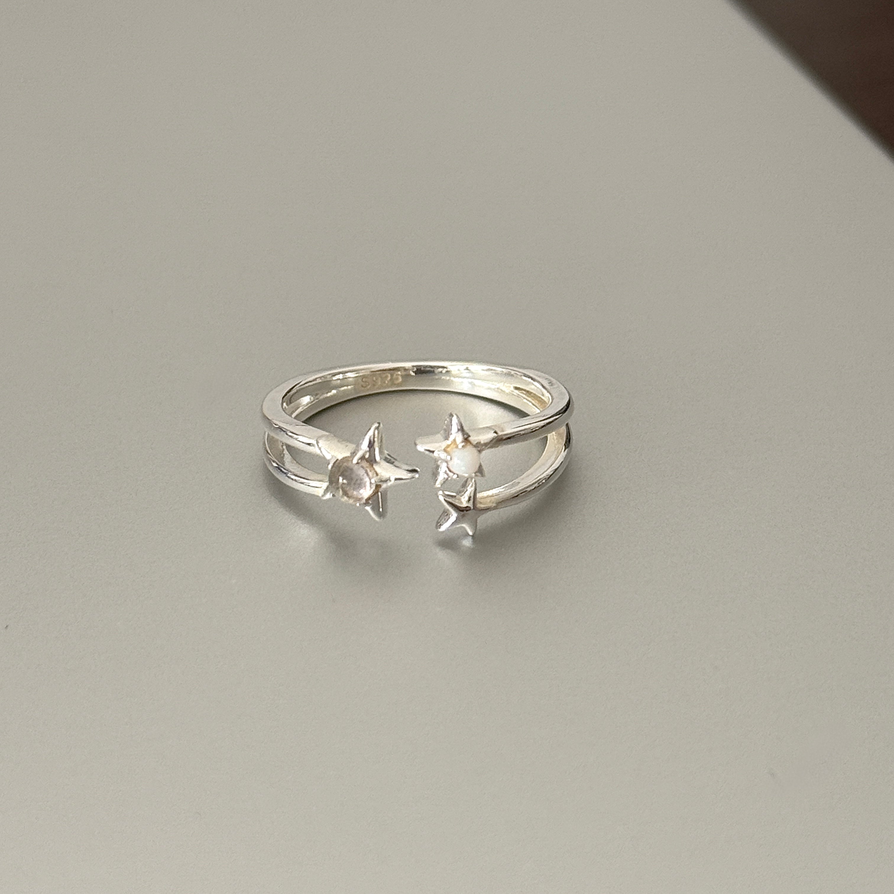 Whimsical 925 sterling silver celestial open ring featuring double star motifs with moonstone accents, polished metallic finish for modern celestial jewelry.