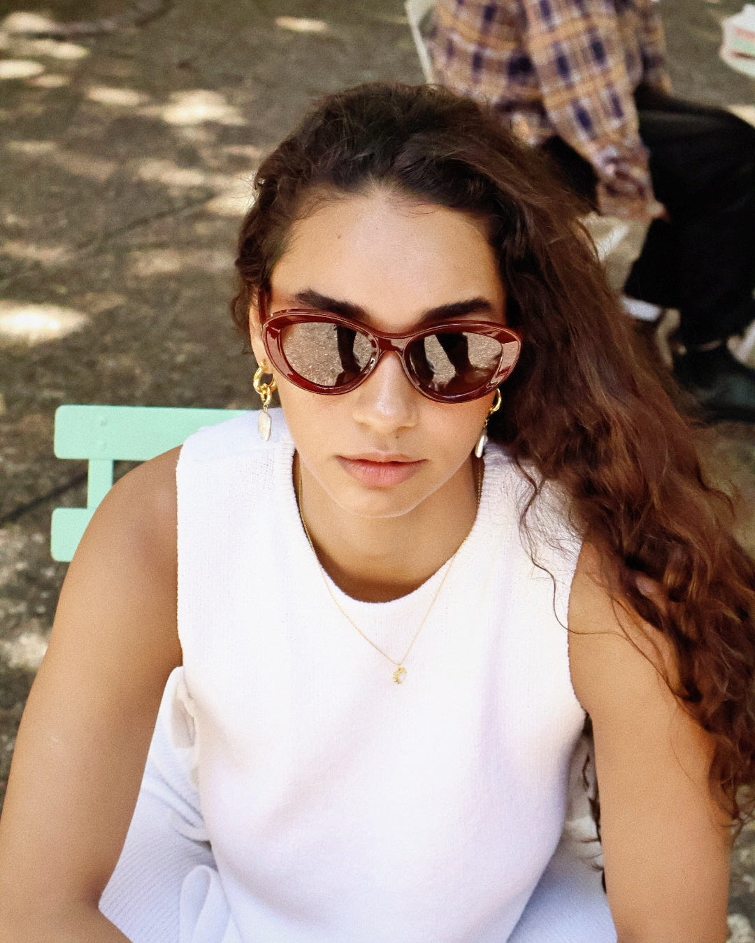 Bold black cat-eye sunglasses with thick frames, polarized lenses with UV protection, retro aesthetic eyewear for women. Brown wood grain pattern cat-eye sunglasses with tea-tinted polarized lenses and UV protection, vintage organic style eyewear.