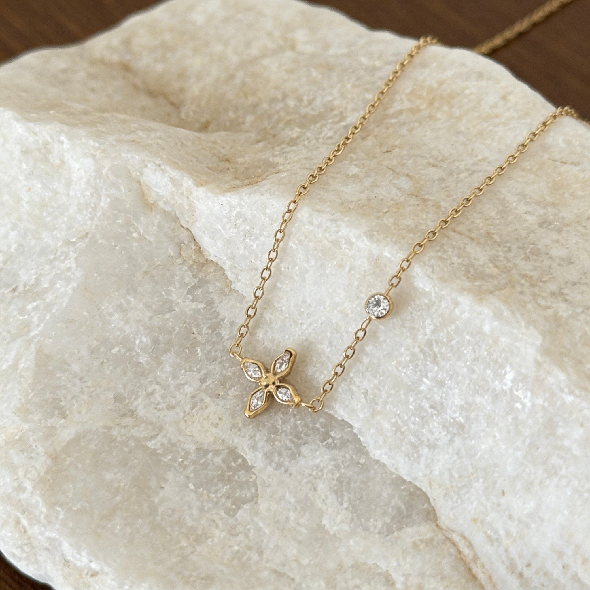 18K gold plated stainless steel necklace featuring a dainty sparkling cubic zirconia flower pendant and a single bezel-set crystal on a thin gold chain