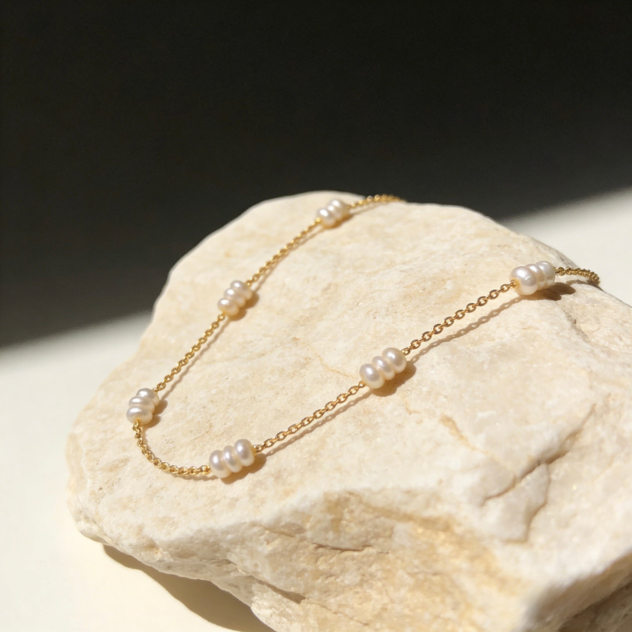 Dainty 18K gold plated station necklace featuring small white freshwater rice pearls spaced evenly on a fine gold chain