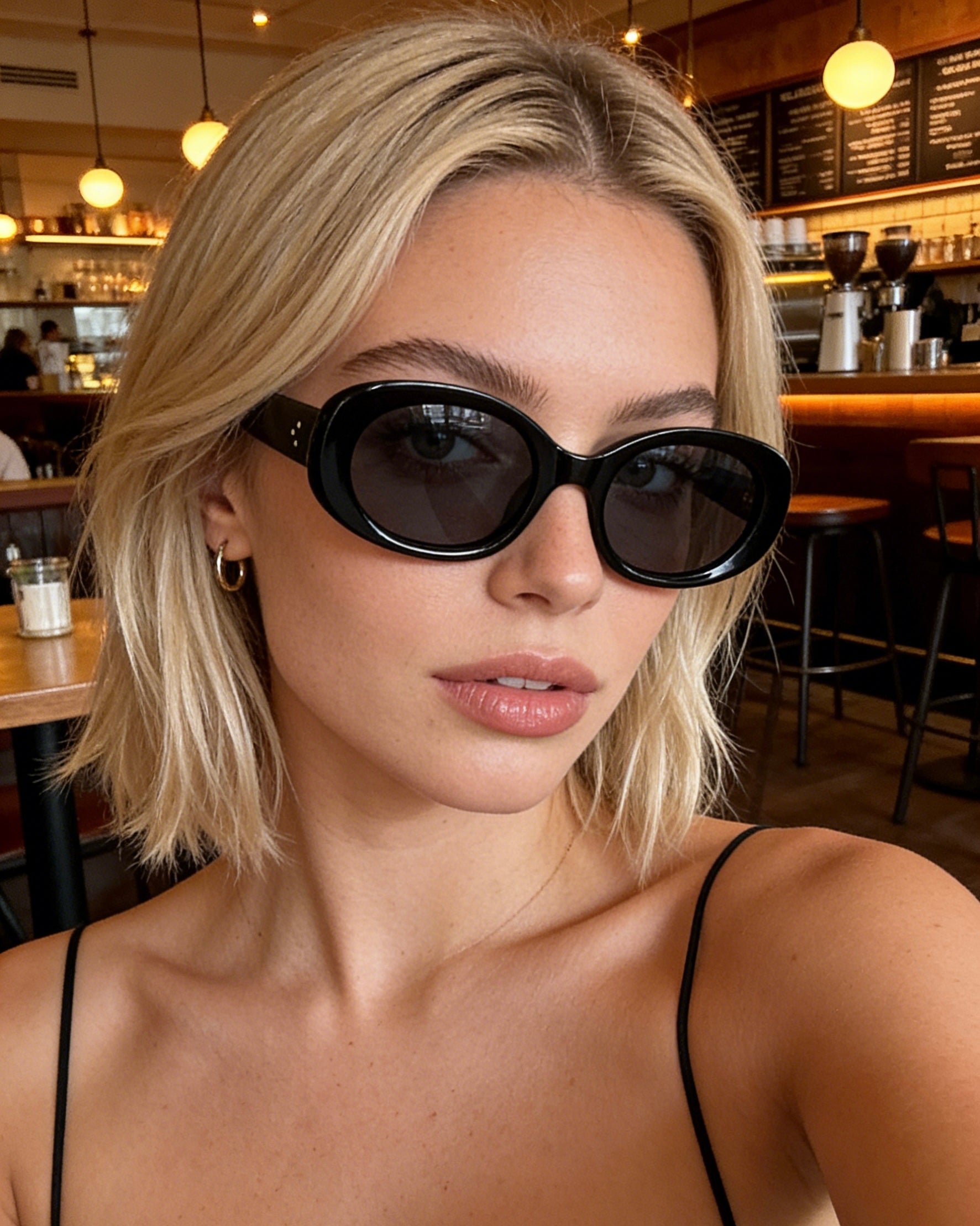 Minimalist black bold oval sunglasses featuring dark polarized lenses and 100% UV protection, aesthetic chic fashion eyewear.