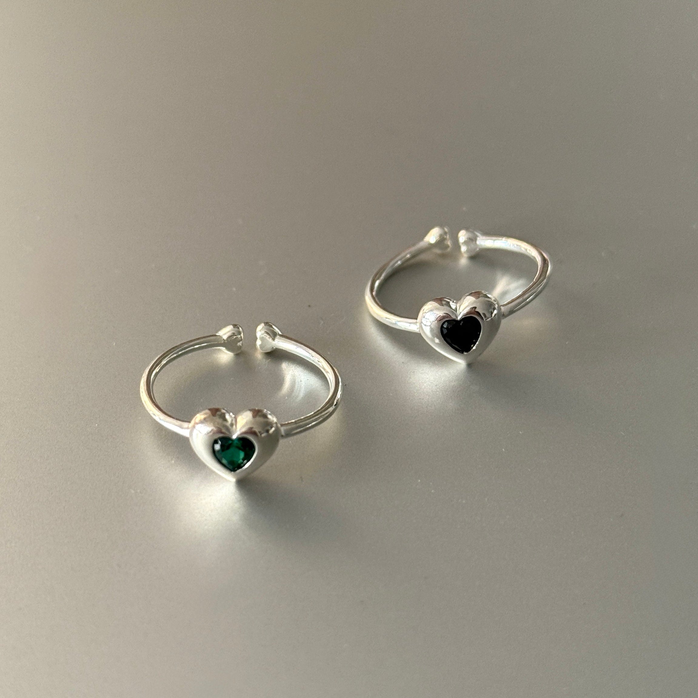 Pair of silver ringswith heart-shaped gemstones.