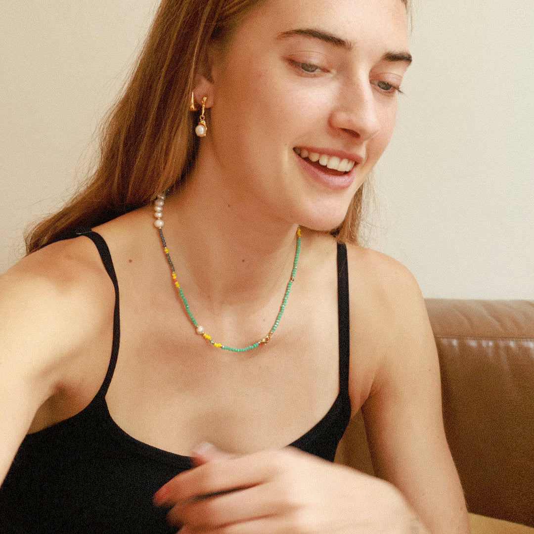 Nova necklace worn alone, featuring turquoise beads with colorful accent beads, freshwater pearls, and 18K gold plated spacers