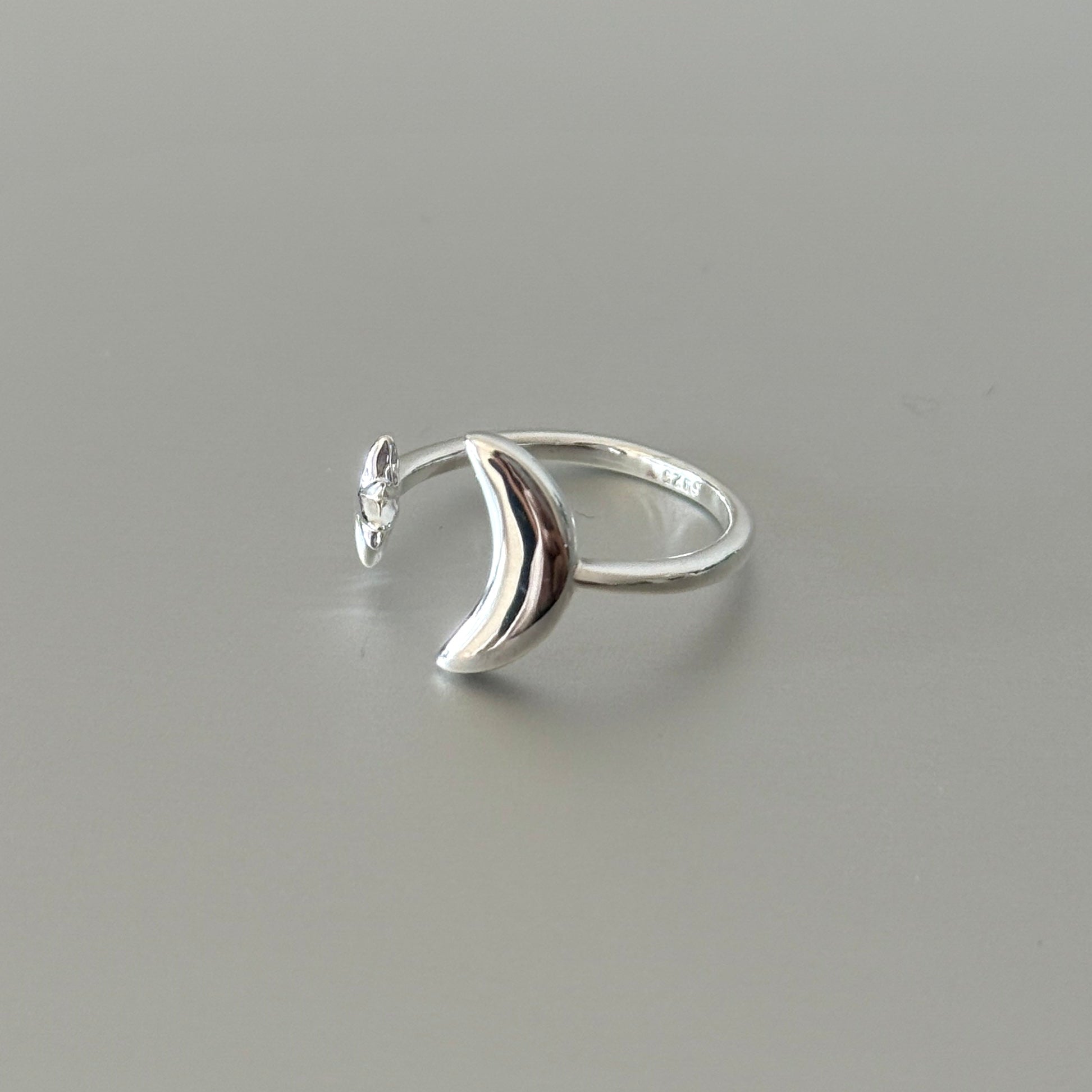 Close-up detail of the Soleil ring, showcasing the textured star and smooth crescent moon in matte finish.