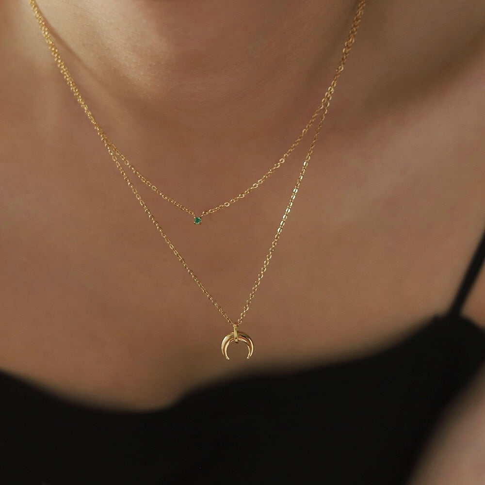 Silas double layer necklace worn alone, featuring 18K gold plated chains with green zircon stone and crescent moon pendant