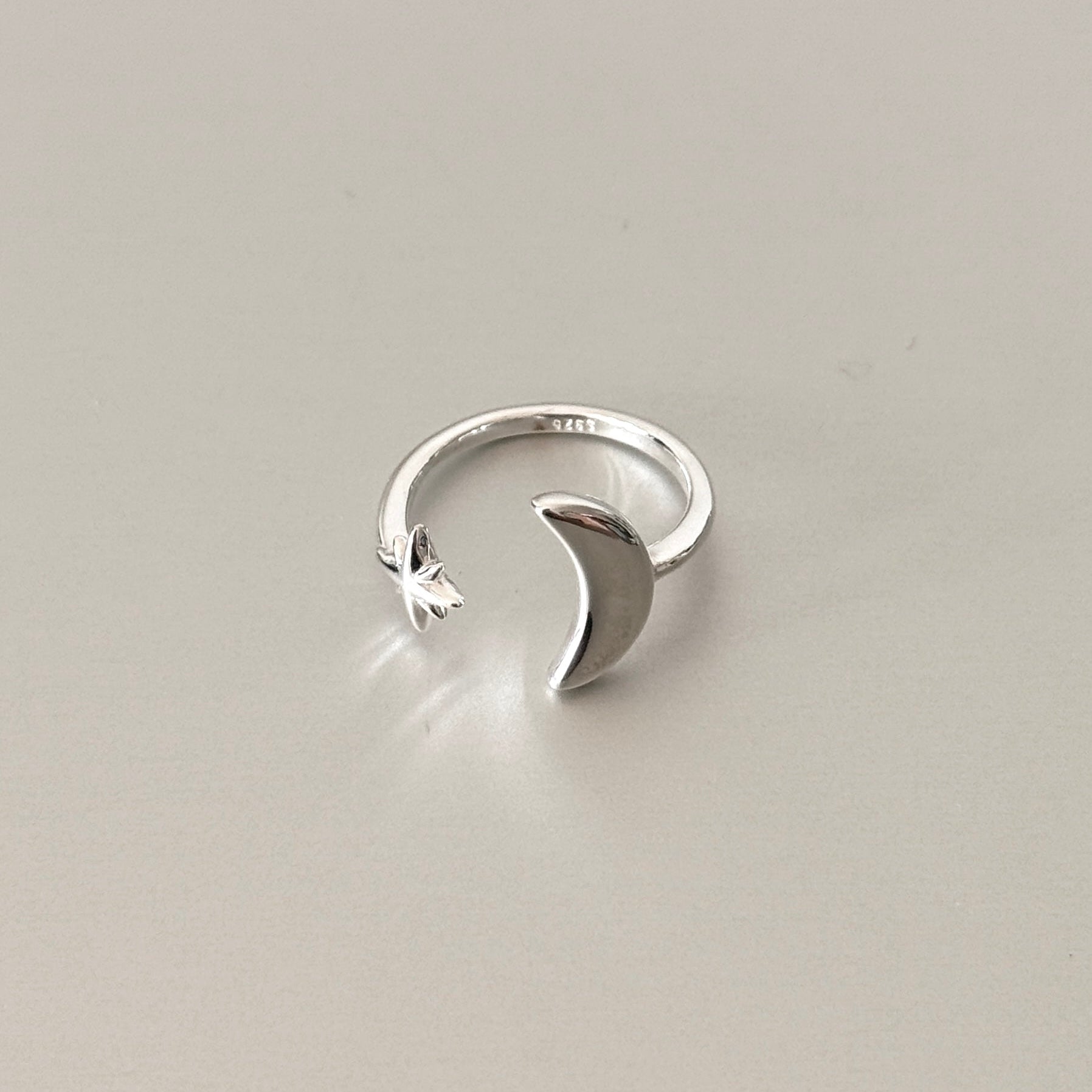 Close-up detail of the Soleil ring, showcasing the textured star and smooth crescent moon in matte finish.