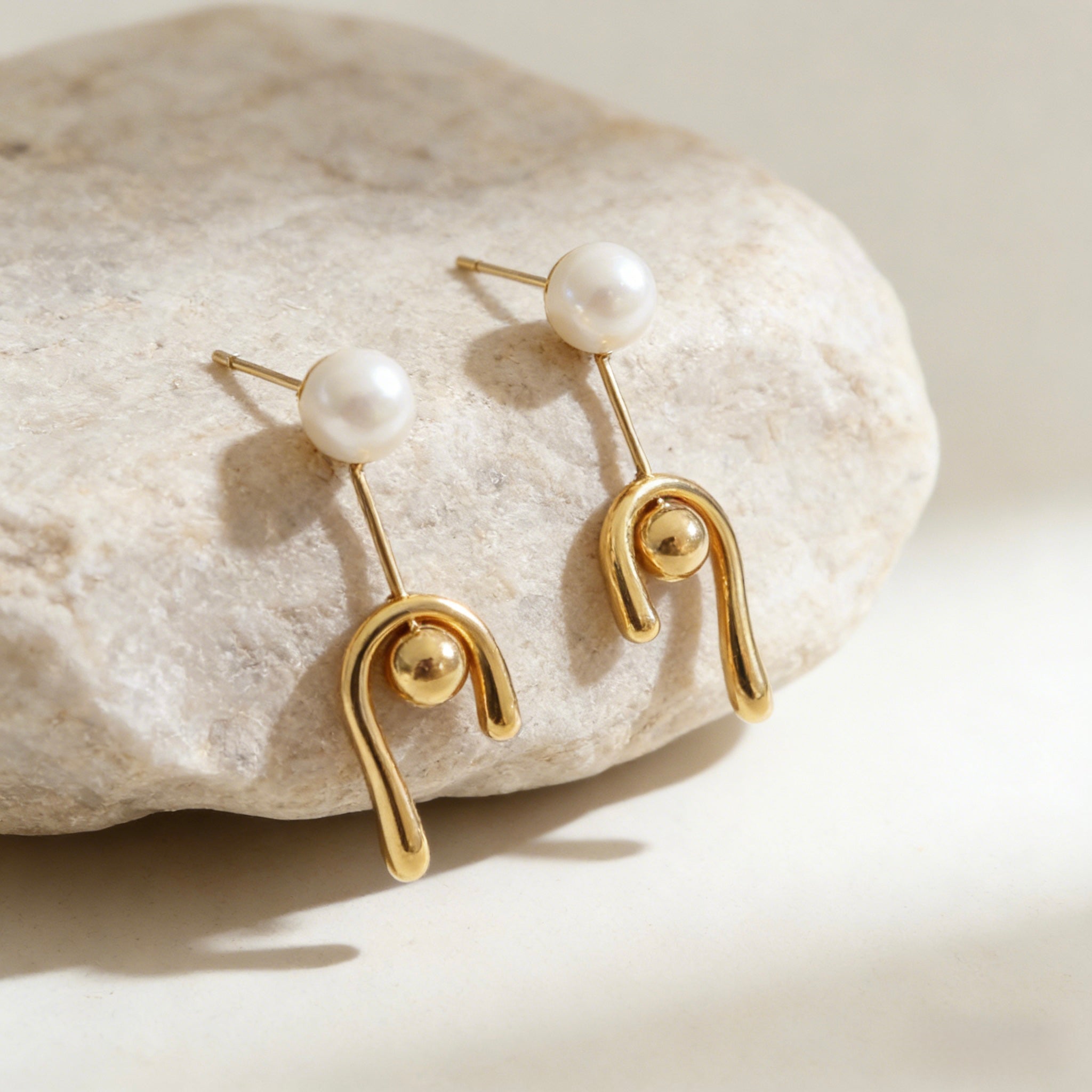 Modern 18K gold plated earrings with a minimalist round pearl stud and a melted liquid-style U-shaped drop featuring S925 sterling silver posts