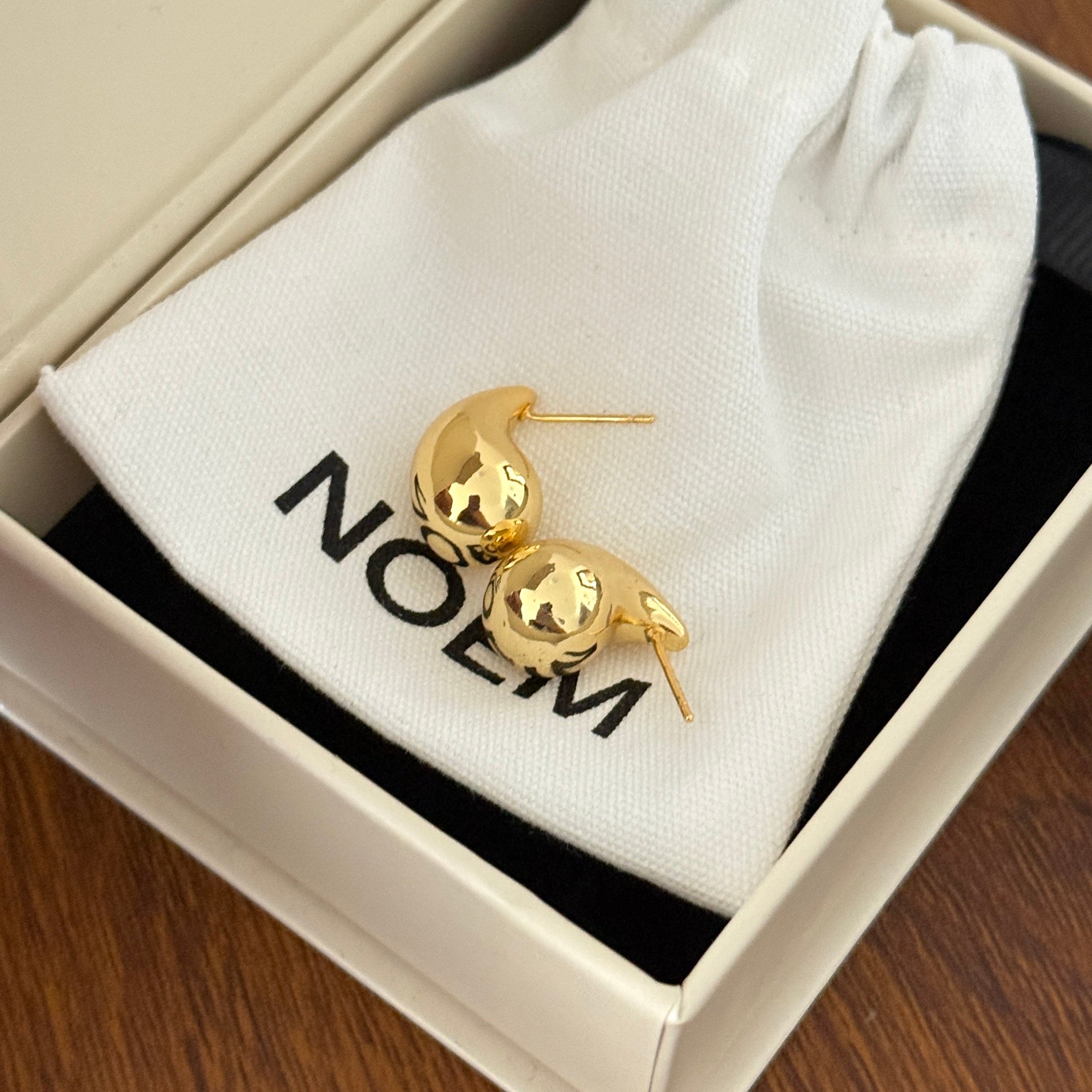 18K gold plated teardrop-shaped stud earrings with sterling silver posts,  minimalist jewelry photography.  chunky bean-style earrings offer a bold yet minimalist statement.