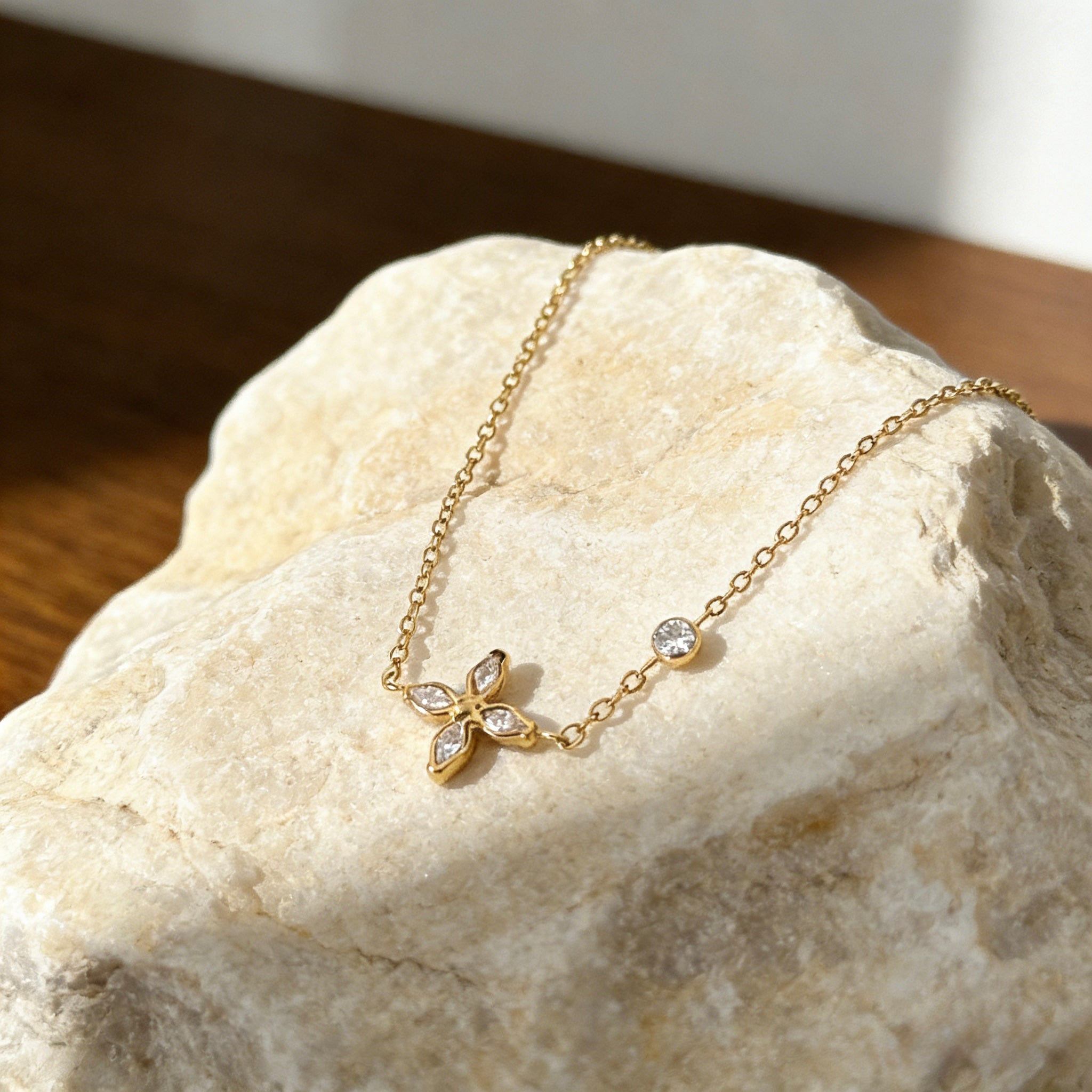 18K gold plated stainless steel necklace featuring a dainty sparkling cubic zirconia flower pendant and a single bezel-set crystal on a thin gold chain