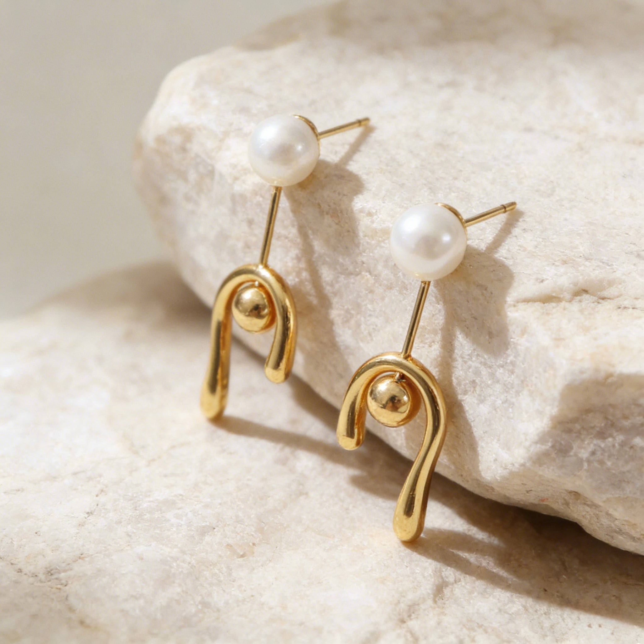 Modern 18K gold plated earrings with a minimalist round pearl stud and a melted liquid-style U-shaped drop featuring S925 sterling silver posts