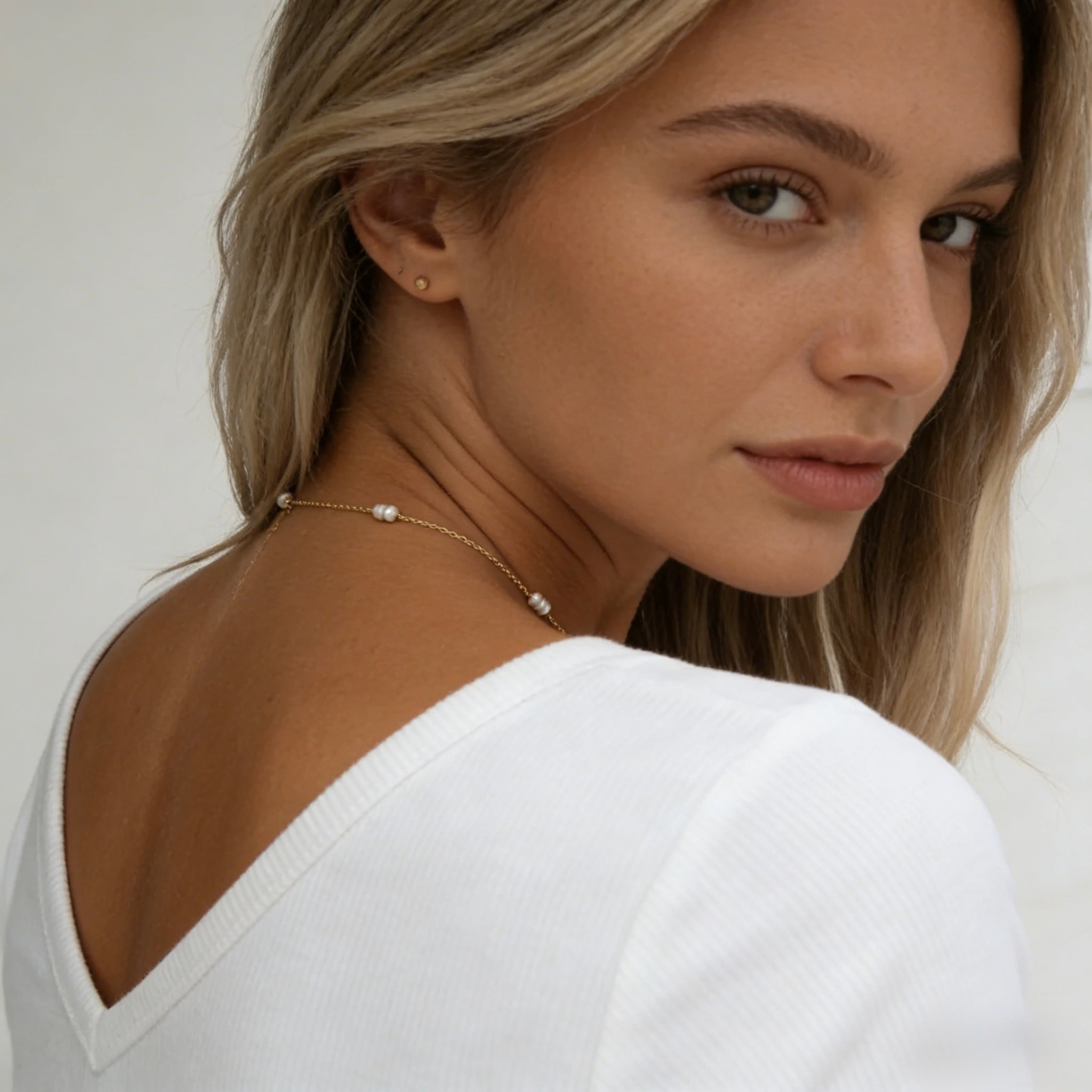 Dainty 18K gold plated station necklace featuring small white freshwater rice pearls spaced evenly on a fine gold chain