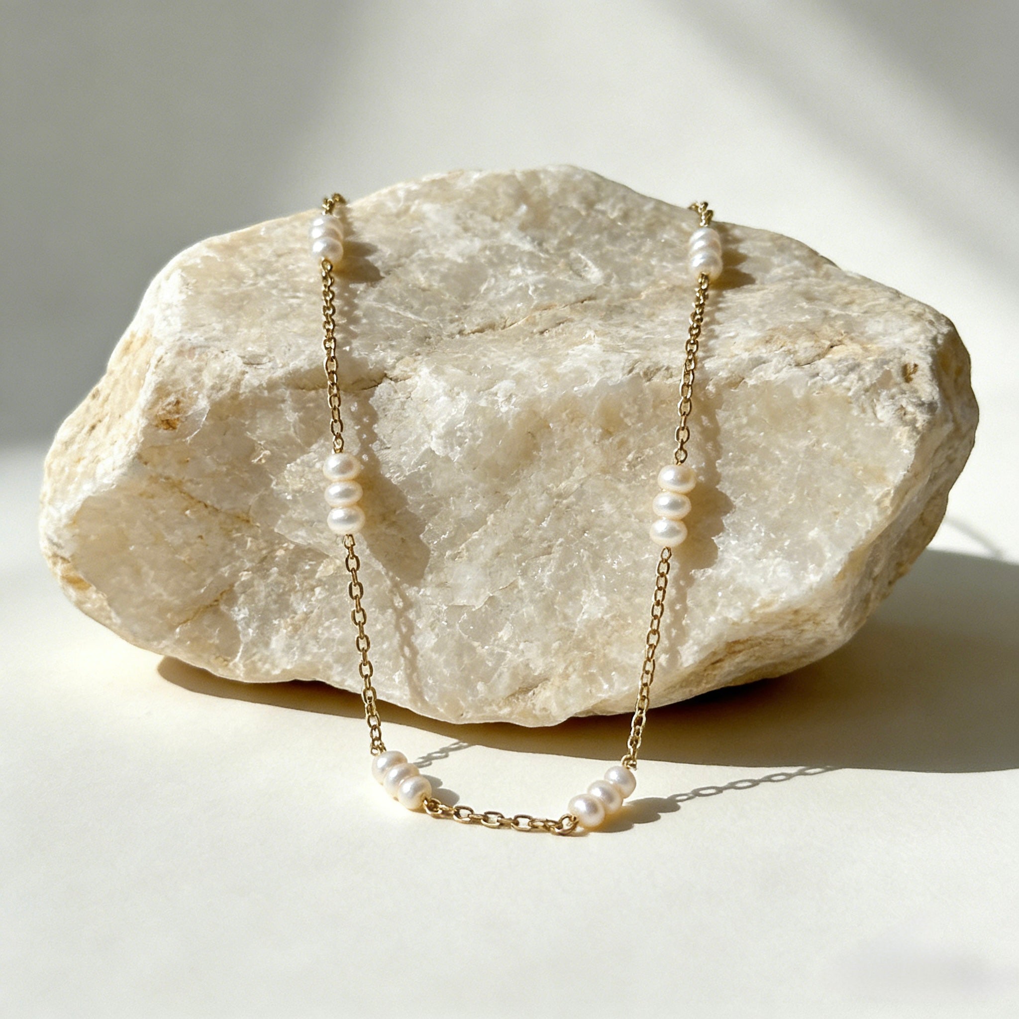 Dainty 18K gold plated station necklace featuring small white freshwater rice pearls spaced evenly on a fine gold chain