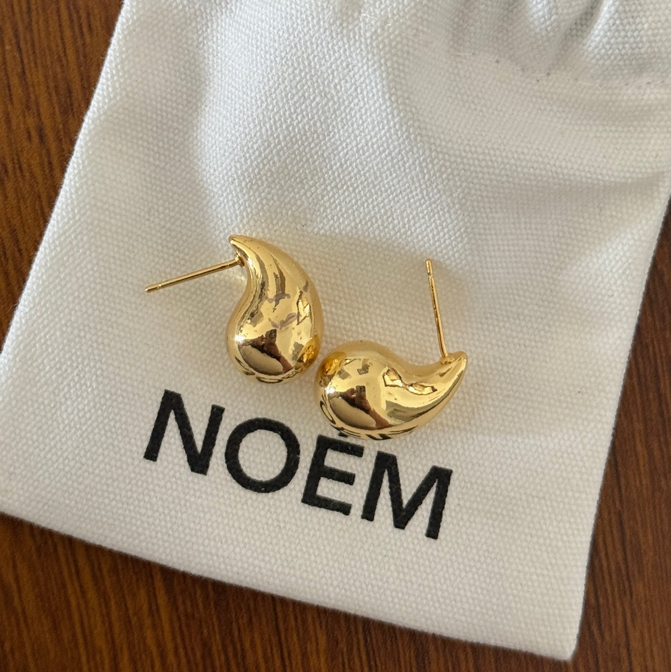18K gold plated teardrop-shaped stud earrings with sterling silver posts,  minimalist jewelry photography.  chunky bean-style earrings offer a bold yet minimalist statement.
